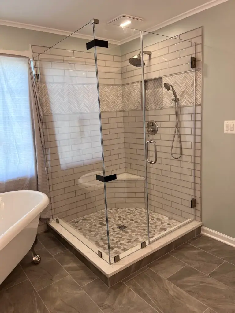 Frameless corner shower enclosure with matte black hardware and subway tile
