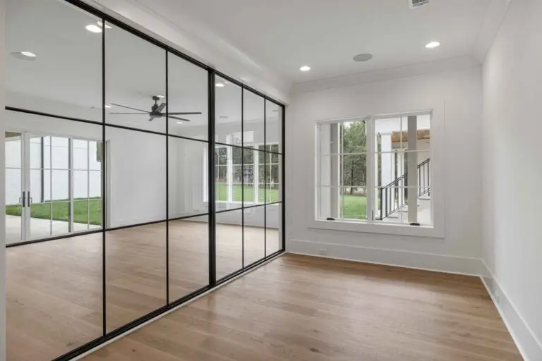 Black-framed glass wall dividing a bright room