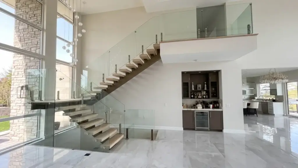 Frameless glass stair railing on a floating staircase with stainless standoffs