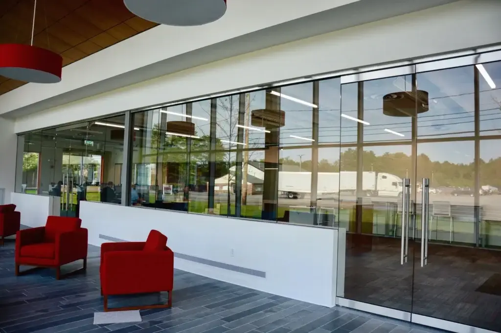 All glass entrance doors and glass wall beside a reception lounge