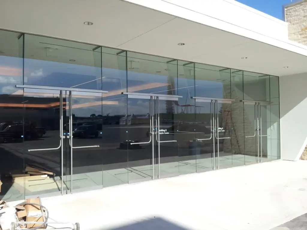 All glass storefront entrance doors with stainless rails at a media center