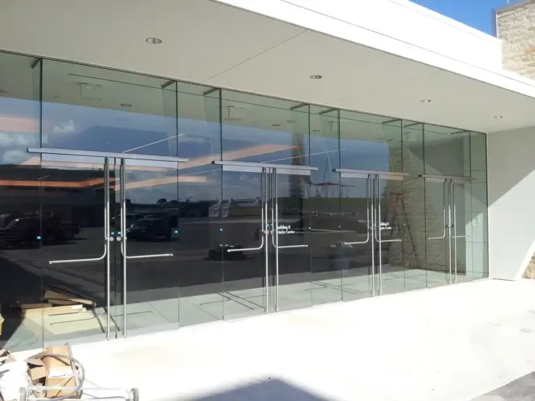 All glass storefront entrance doors with stainless rails at a media center