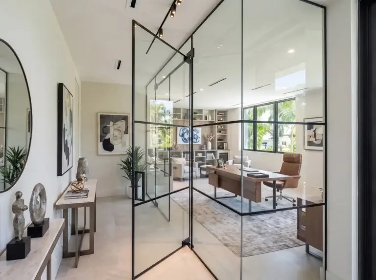 Black-framed glass wall and door opening into a home office