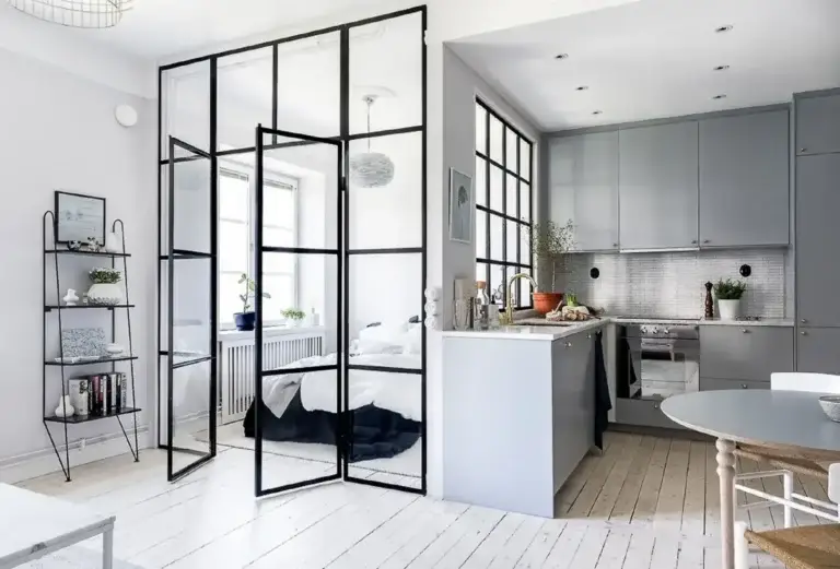Black grid glass partition with double doors in a studio apartment