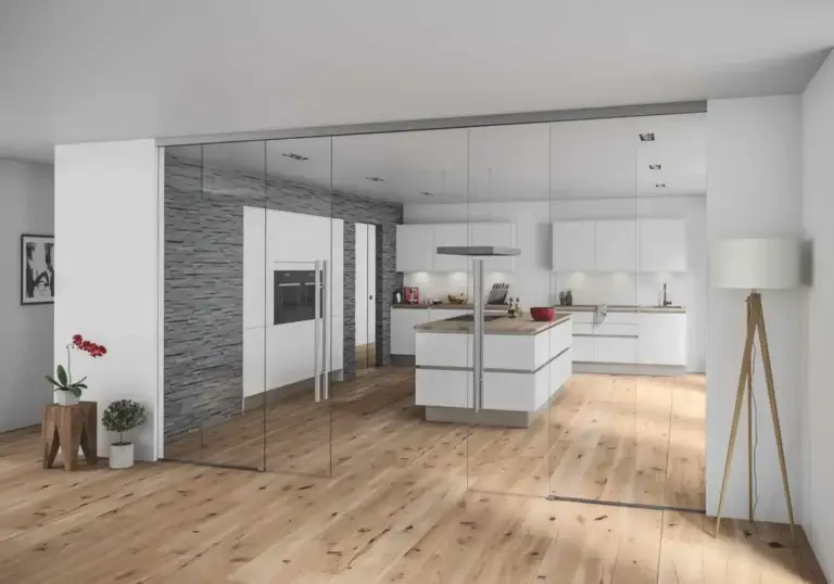 Clear glass wall separating an open kitchen from the living area