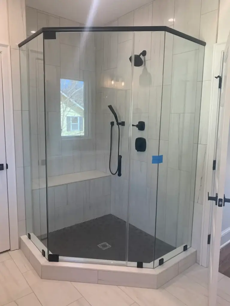 Neo-angle frameless glass shower with a black header and black hardware