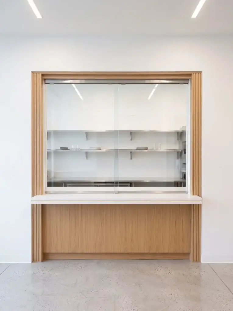 Sliding glass transaction window set in a wood-framed wall opening