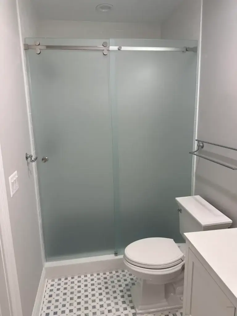 Sliding shower door with frosted glass over a shower base