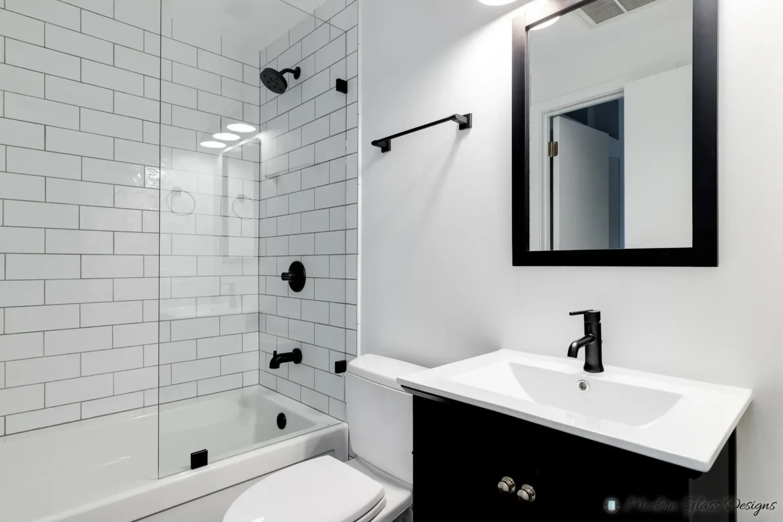 A bathroom with a black cabinet and subway tiles.