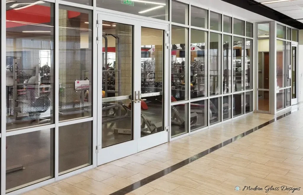 Clear anodized aluminum storefront running along a covered retail walkway