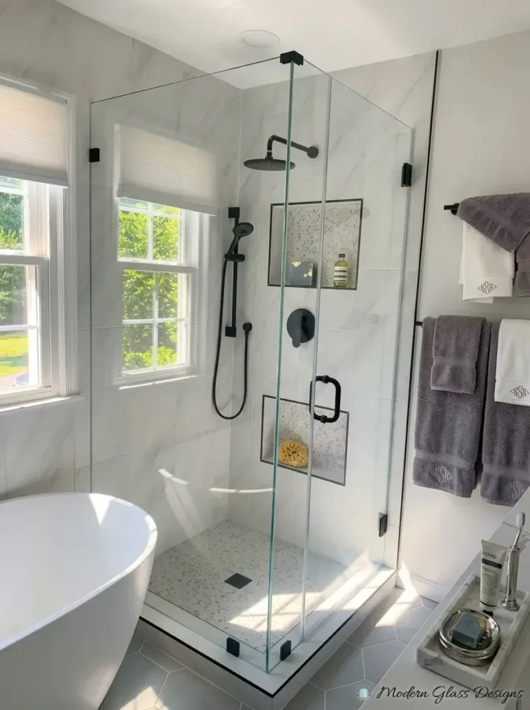 Frameless corner shower with matte black clamps beside a freestanding tub