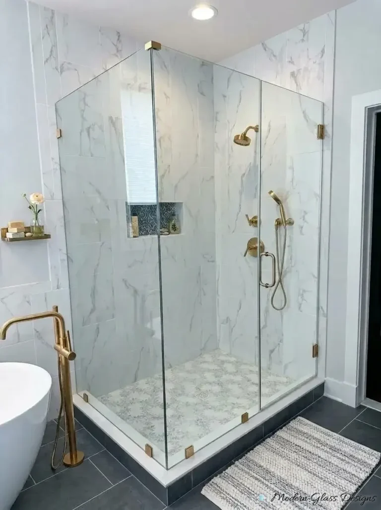 Frameless corner shower enclosure with brushed gold hardware