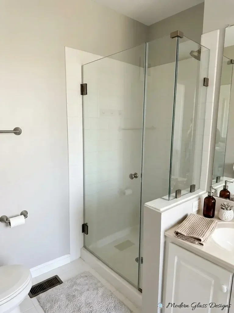 Frameless corner shower door and panel with brushed nickel hinges