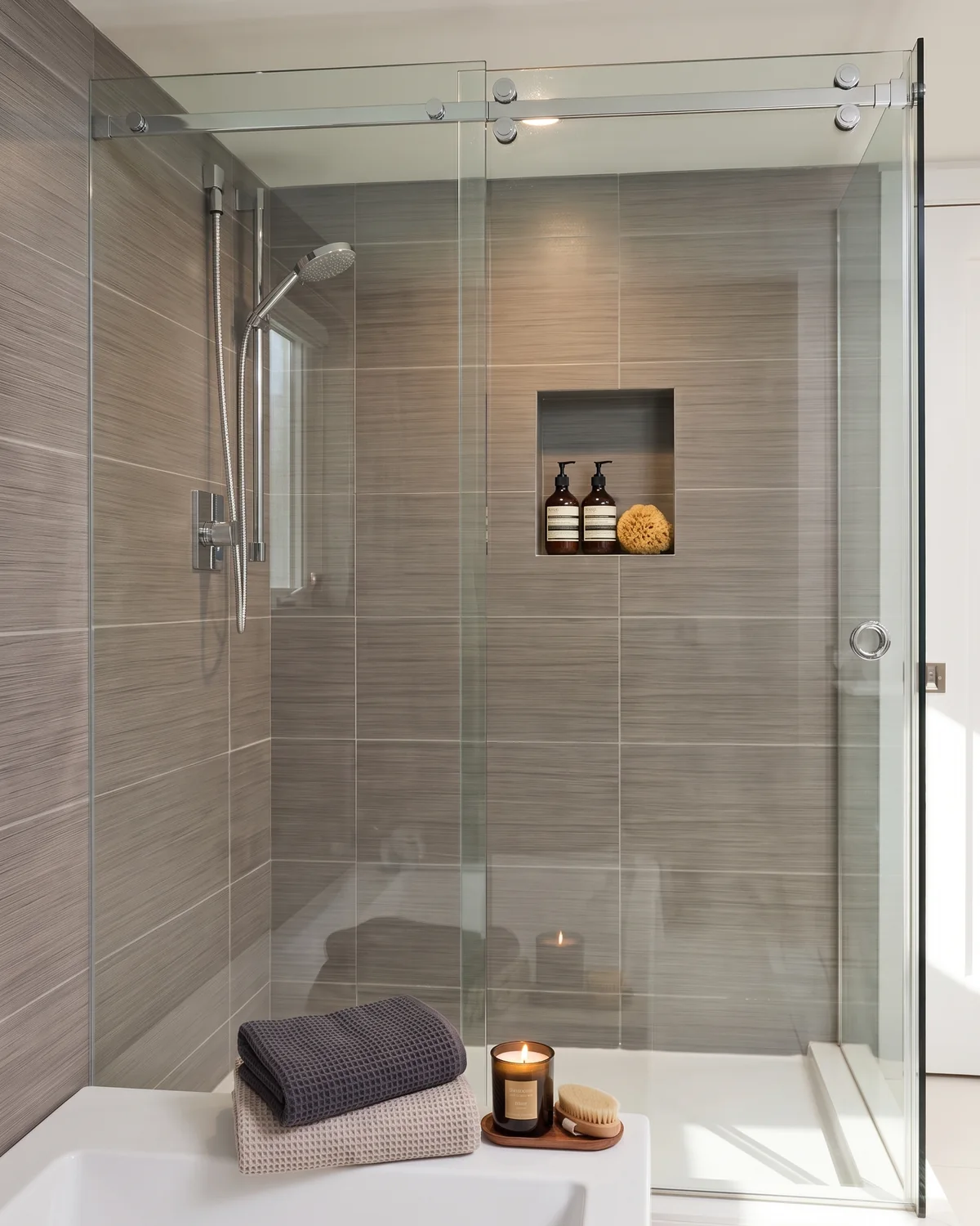 CRL Bristol single slider shower door with one sliding door and one fixed panel in a gray tile corner shower