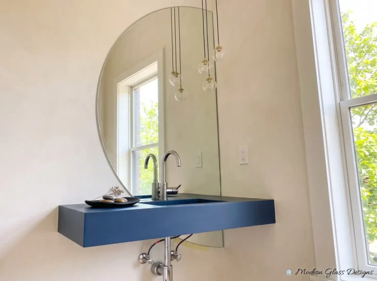 Custom-shaped mirror with a curved top above a blue floating sink