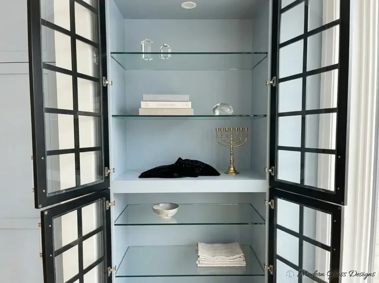 Glass shelves behind black grid cabinet doors