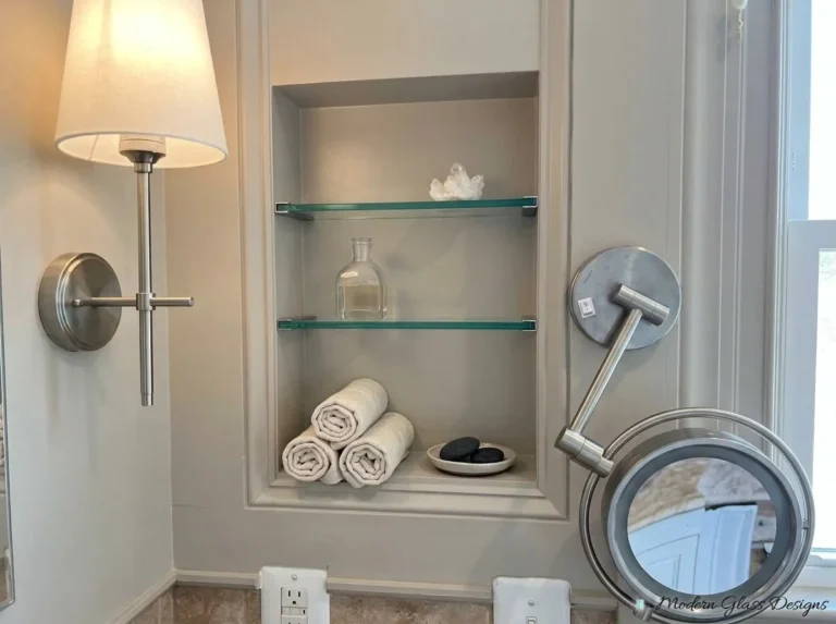 Glass shelves in a recessed wall niche with towels