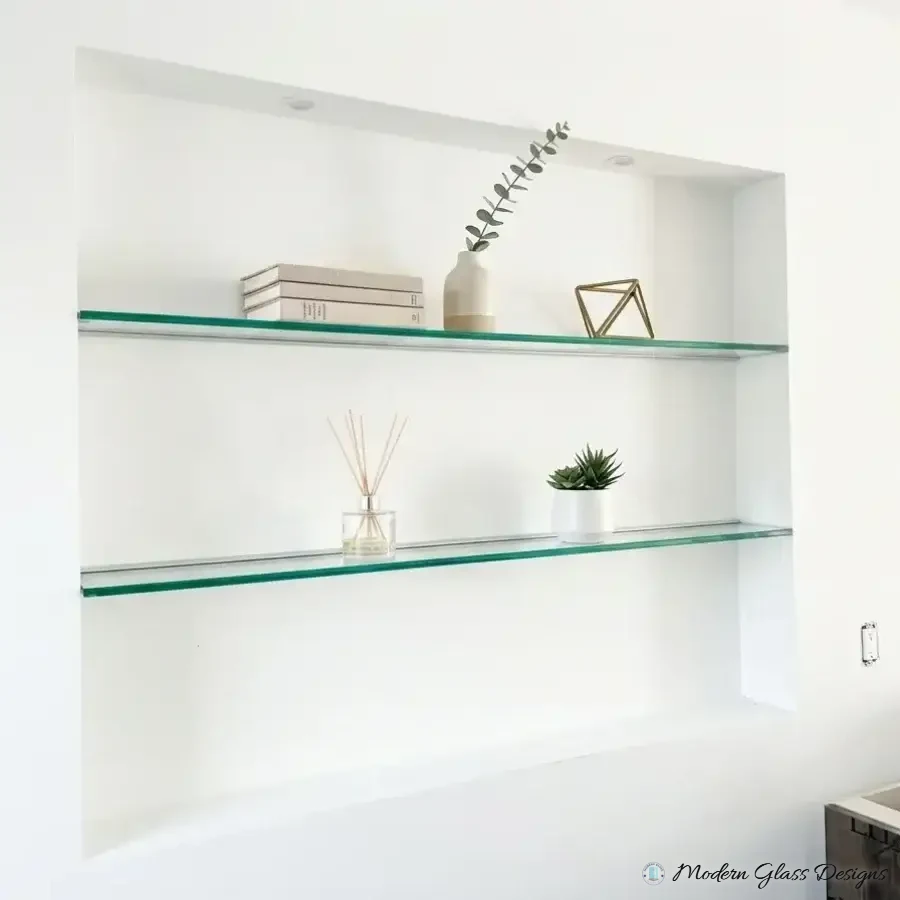 Glass shelves spanning a white wall niche