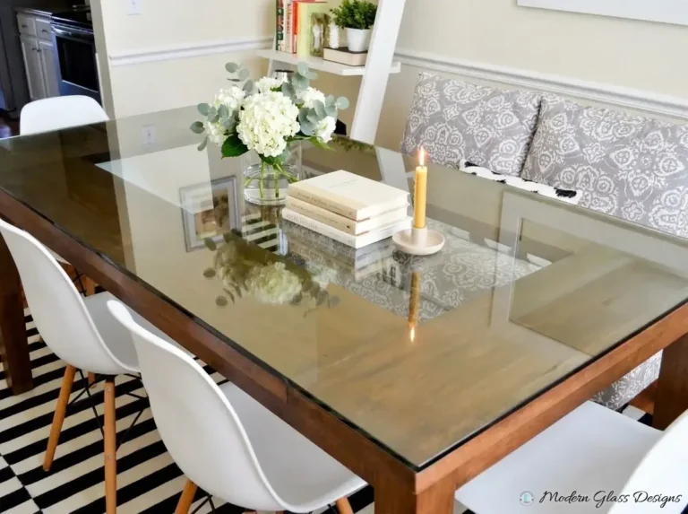 Glass top on a wood dining table with white chairs
