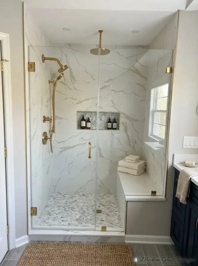 Frameless inline shower door and panels with brushed gold hinges and clamps