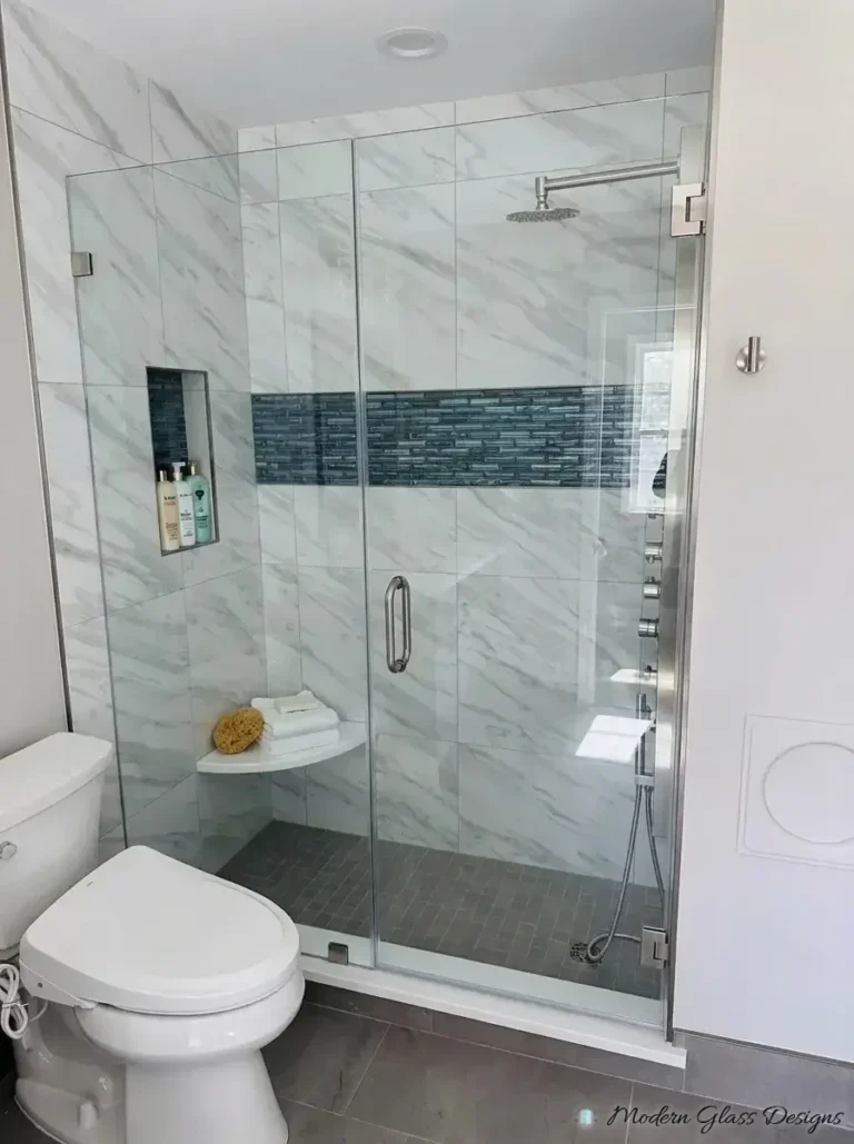 Frameless inline shower door and fixed glass panel with brushed nickel hinges