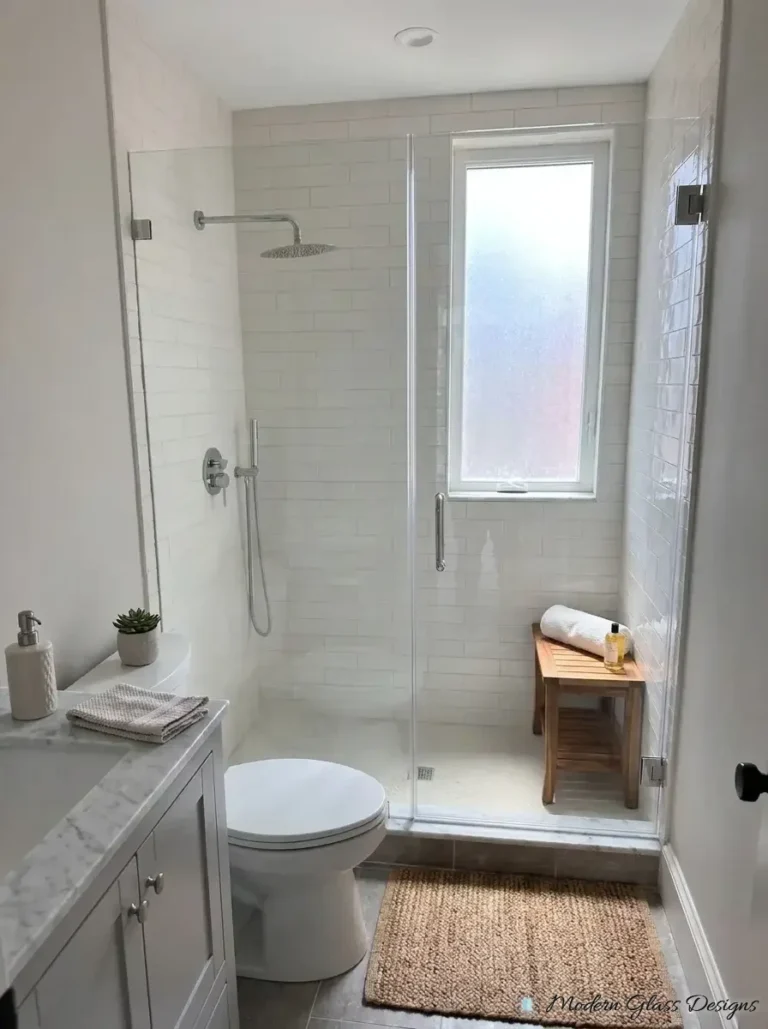 Frameless inline shower door and panel in a subway tile shower with a window