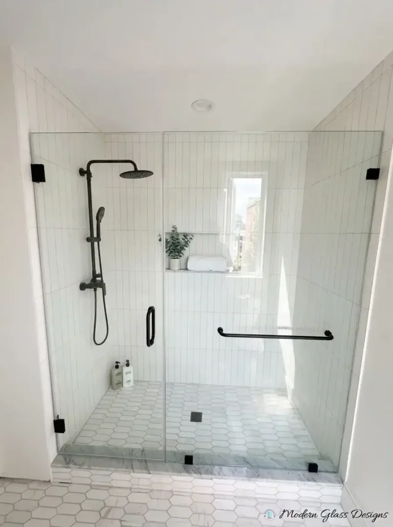 Inline frameless shower door between two fixed panels with matte black clamps