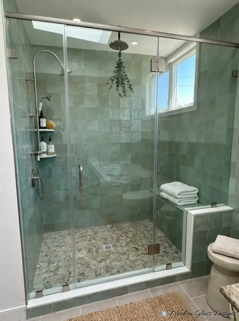 Frameless inline shower with header bar, knee wall panel and door on green tile