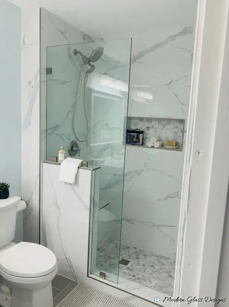 Fixed glass shower screen on a knee wall with marble tile