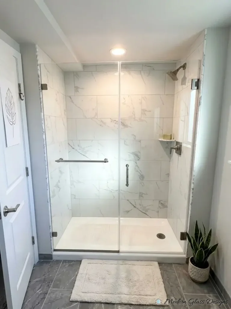 Frameless inline shower panel with towel bar and hinged door over a shower base