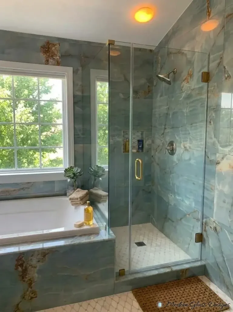 Frameless corner shower with glass return on a tub deck, brushed gold hardware
