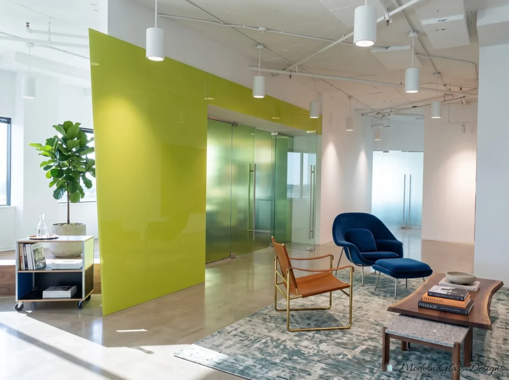 Lime green back-painted glass feature wall beside glass office doors in an open office