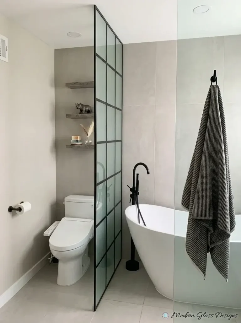 Black grid glass partition beside a freestanding tub
