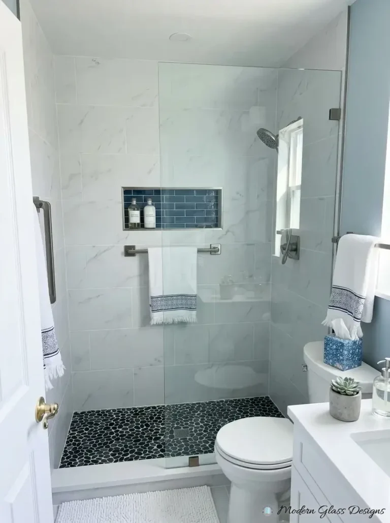 Fixed glass shower panel with brushed nickel clamps