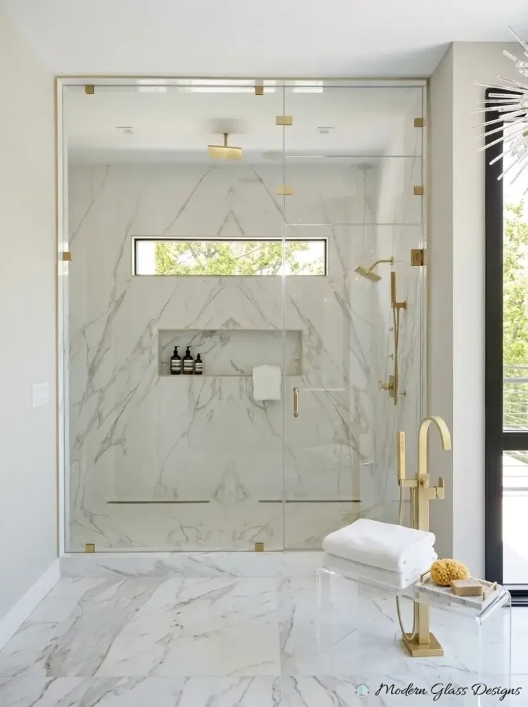 Steam shower front with brushed brass clamps, door and transom