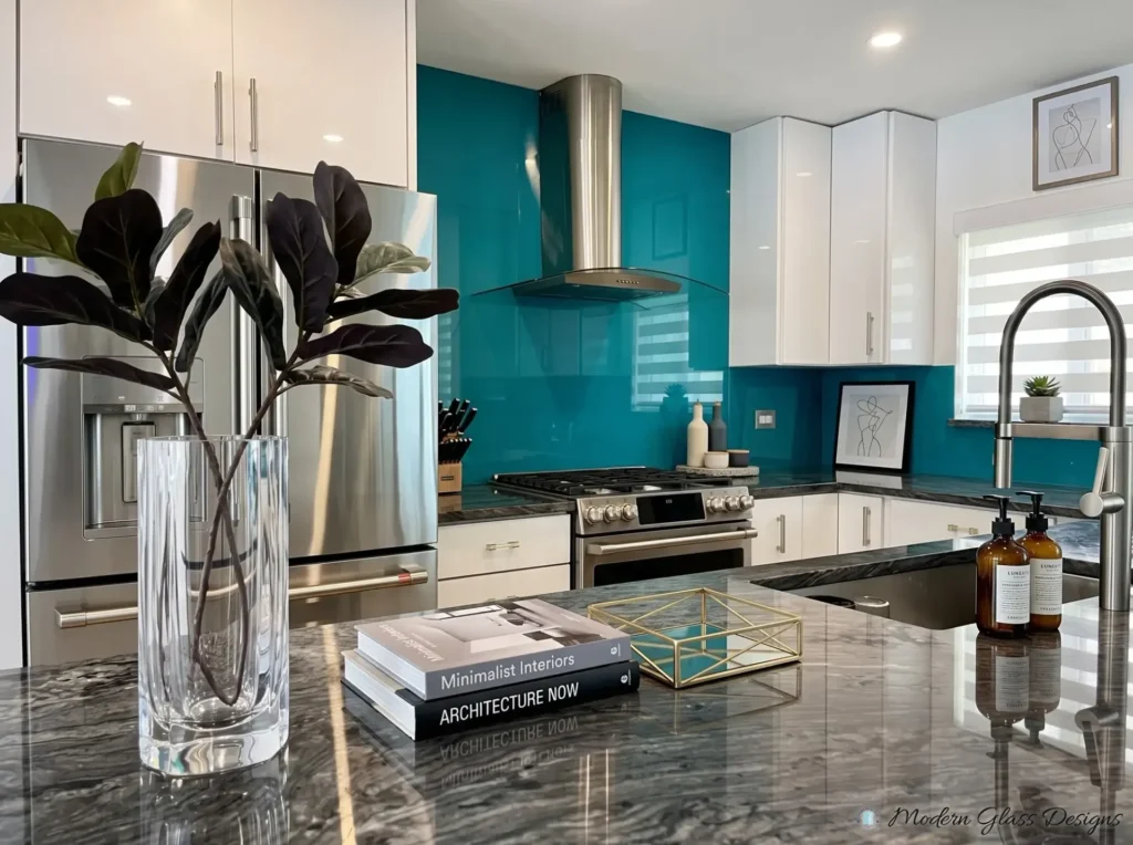 Teal back-painted glass backsplash behind a range and hood in a white kitchen
